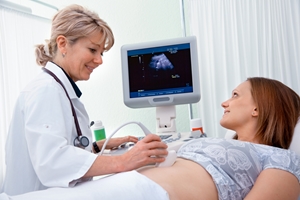 A doctor performs an ultrasound scan on a smiling woman lying on an examination table, ensuring accuracy and care to prevent medical negligence, while the scan image is visible on the monitor beside them.