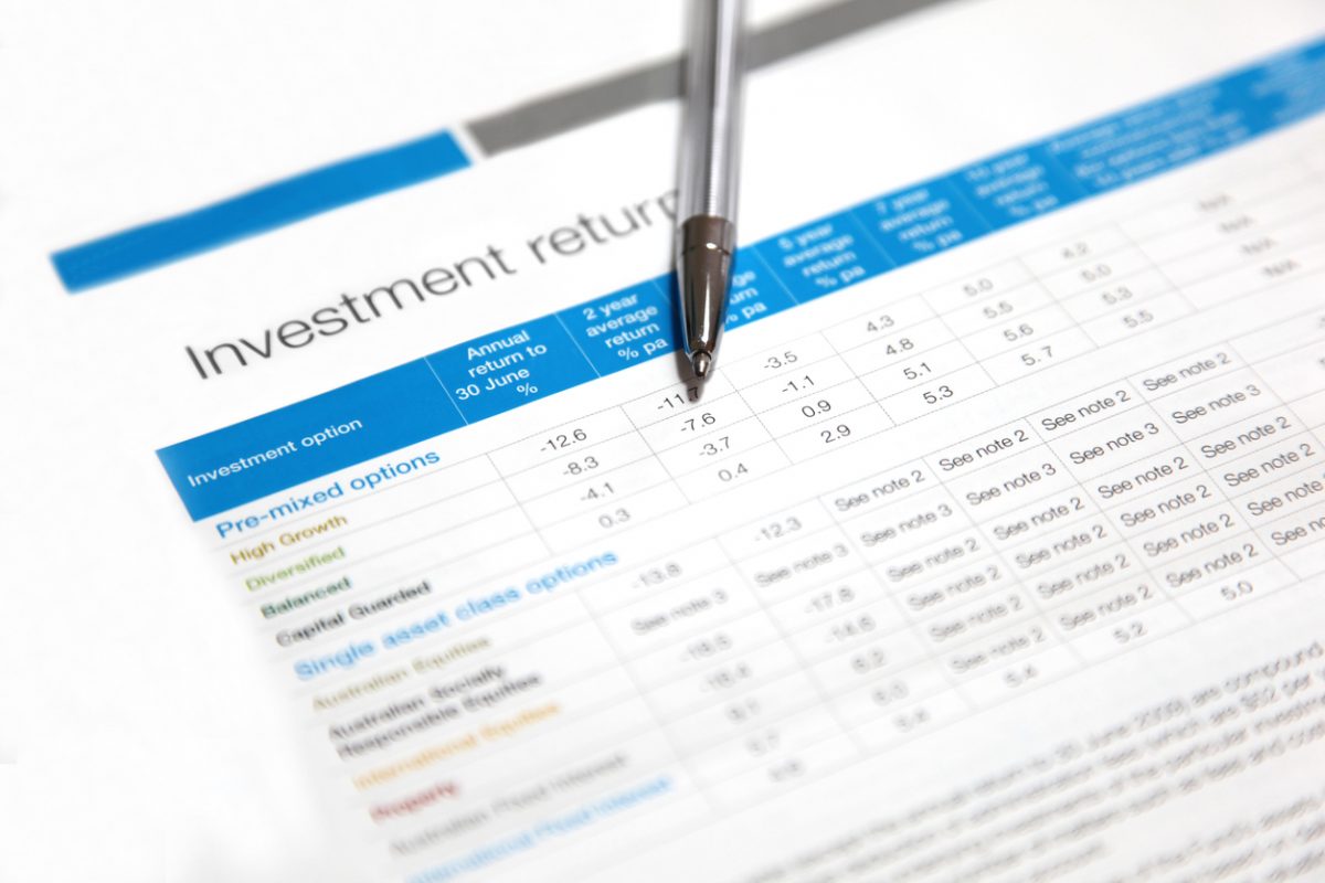 A pen rests on a printed financial document titled “Investment returns,” displaying a table with various investment options and annual return percentages in blue and black text. A pen rests on a printed financial document titled "Investment returns," displaying a table with various investment options and annual return percentages in blue and black text.