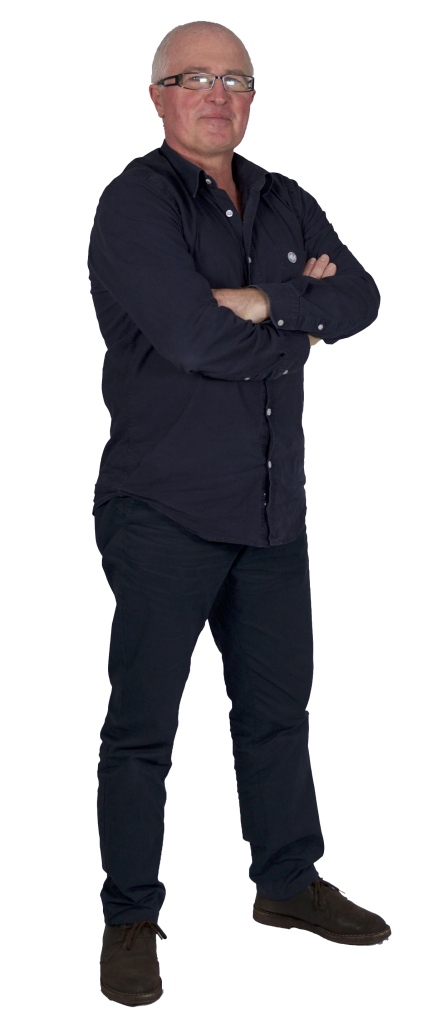 A man with short gray hair and glasses stands with his arms crossed, wearing a dark button-up shirt, dark pants, and brown shoes, facing forward with a neutral expression. A man with short gray hair and glasses stands with his arms crossed, wearing a dark button-up shirt, dark pants, and brown shoes, facing forward with a neutral expression.