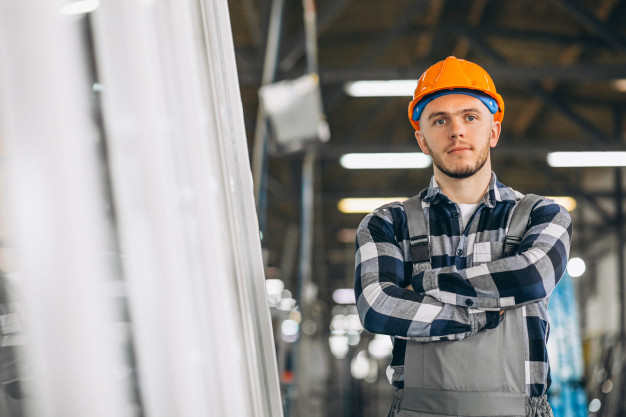 Workers Compensation Lawyer A man wearing a hard hat and overalls stands by a window, highlighting the importance of safety in the construction industry.