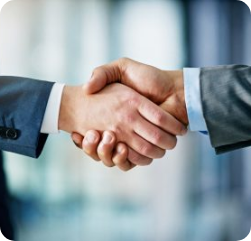 Two people in business suits shaking hands, symbolizing agreement or partnership, with a blurred office background. Two people in business suits shaking hands, symbolizing agreement or partnership, with a blurred office background.