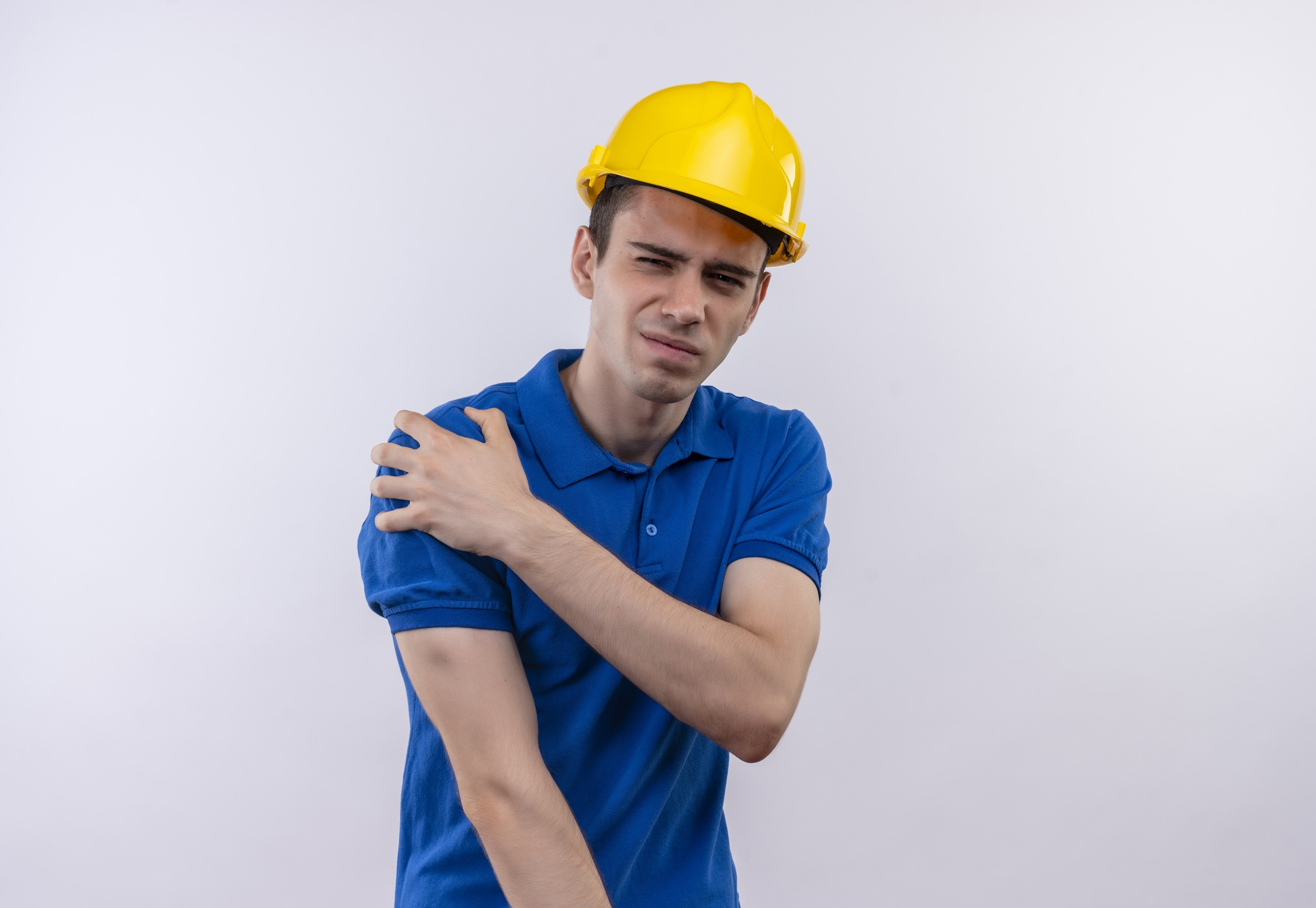 young builder man wearing construction uniform and safety helmet doing unhappy face and suffers from pain over white isolated background young builder man wearing construction uniform and safety helmet doing unhappy face and suffers from pain over white isolated background