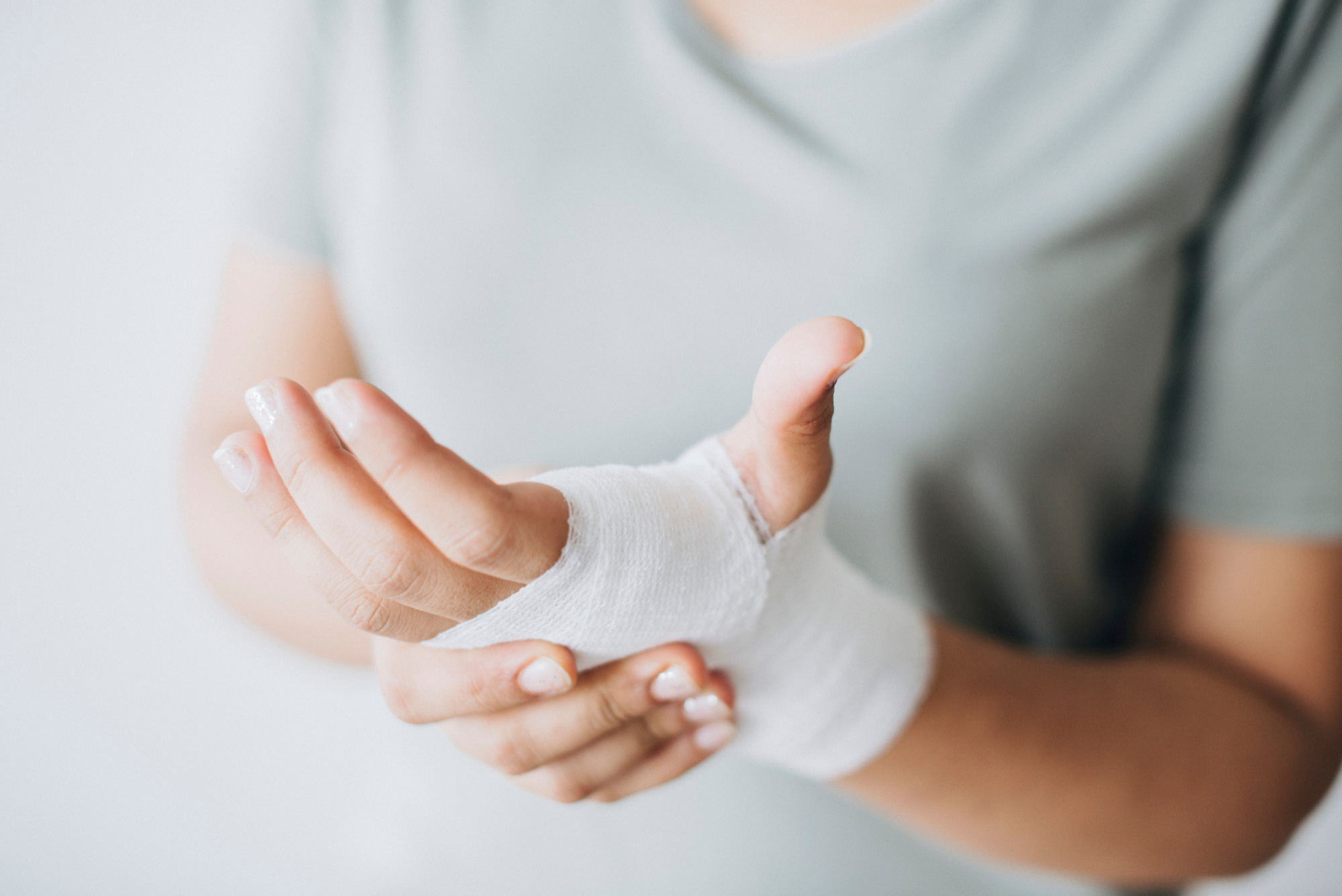 Woman with gauze bandage wrapped around her hand Woman with gauze bandage wrapped around her hand
