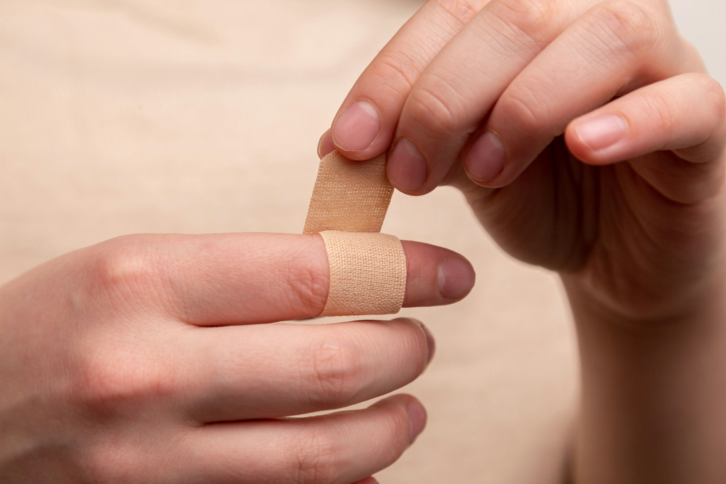 person with band aid on index finger person with band aid on middle finger