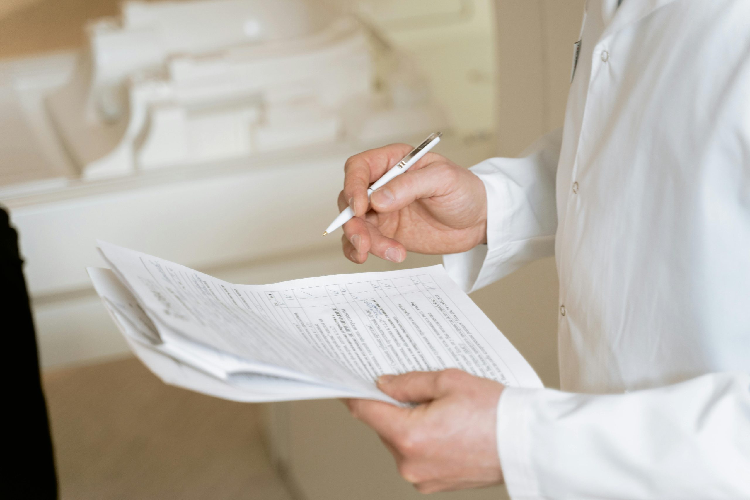 A Person in White Dress Shirt Holding a Pen and Paper